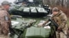Украинские военнослужащие у поврежденного российского танка Т-72БЗ во время масштабного вторжения России в Украину. Донецкая область, 13 апреля 2022 года