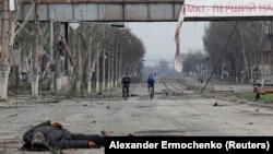 The body of a civilian killed during Russia's assault lies on a street in the devastated southern port city of Mariupol on April 15.