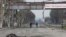 Two people on bicycles and a dead body on devastated street in Mariupol_Ukraine