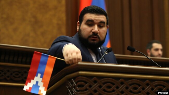 Armenia - Pro-government parliamentarian Vahagn Aleksanian removes a Karabakh flag from the parliament rostrum, April 12, 2022.