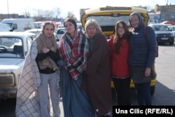 Natalia dhe vajzat e saj, Julia dhe Tatiana, me shoqen e tyre, Oxana, dhe vajzën e saj, Sofija, përballë qendrës së vjetër tregtare Tesco në Przemysl të Polonisë, 11 prill 2022