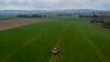 A farmer fertilizes a field on the outskirts of Frankfurt, Germany. Russia's war in Ukraine has pushed up fertilizer prices that were already high, made scarce supplies rarer still, and squeezed farmers.