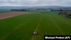 A farmer fertilizes a field on the outskirts of Frankfurt, Germany. Russia's war in Ukraine has pushed up fertilizer prices that were already high, made scarce supplies rarer still, and squeezed farmers.