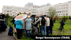 Journalistst gather outside a school where a teenager fired shots and tossed smoke grenades, in Ivanteyevka, a town in the northeastern suburbs of Moscow, on September 5.