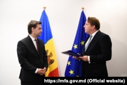 Міністр закордонних справ Молдови Ніку Попеску (ліворуч) отримує опитувальник для кандидатування його країни до ЄС від комісара ЄС із питань розширення Олівера Варгеї. Люксембург, 11 квітня 2022 року