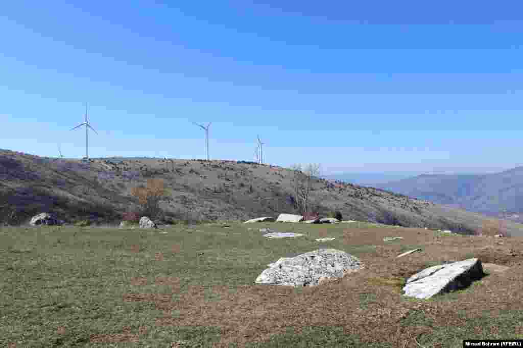 Nekropola stećaka kod sela Dobrč, najzapadnija od nekropola na platou Podveležja; na slici se u pozadini vidi nedavno izgrađeni vjetropark Podveležje. &nbsp;