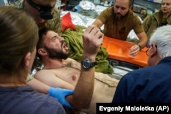 Ukrainian military medics move an injured soldier on a stretcher at a stabilization point near Toretsk.