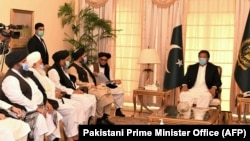 Pakistani Prime Minister Imran Khan (right) talks with Taliban co-founder Mullah Abdul Ghani Baradar (fifth left) during a meeting along with his delegation in Islamabad on December 18, 2020.