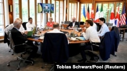 A G7 vezetői egy kerek asztalnál ülve hallgatják Volodimir Zelenszkij ukrán elnököt videokapcsolaton keresztül a németországi Elmau várában 2022. június 27-én