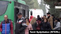 Bishkekdagi avtobus bekatida transport kutayotgan odamlar.