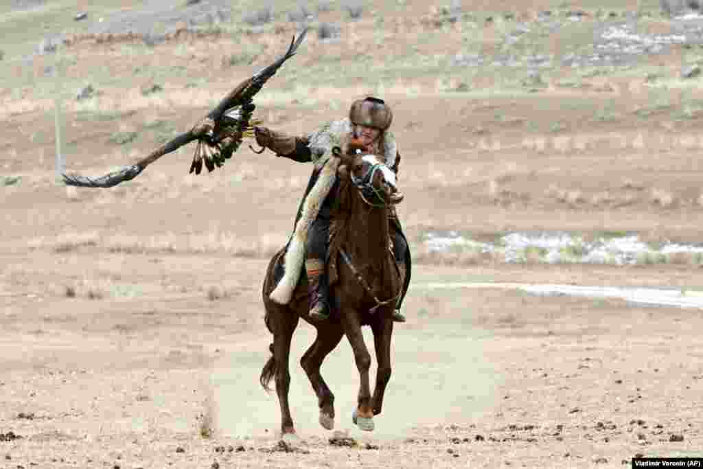 A Kyrgyz man rides a horse holding a golden eagle during a hunting festival in a small mountain village about 250 kilometers southeast of Bishkek. (AP/Vladimir Voronin)