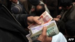 Afghanistan -- Men buy and trade currencies at a money market in Kabul, 28Jan2010