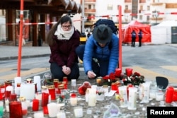 Мъж запалва свещ в памет на жертвите от пожара. Кран Монтана, 2 януари 2026 г.