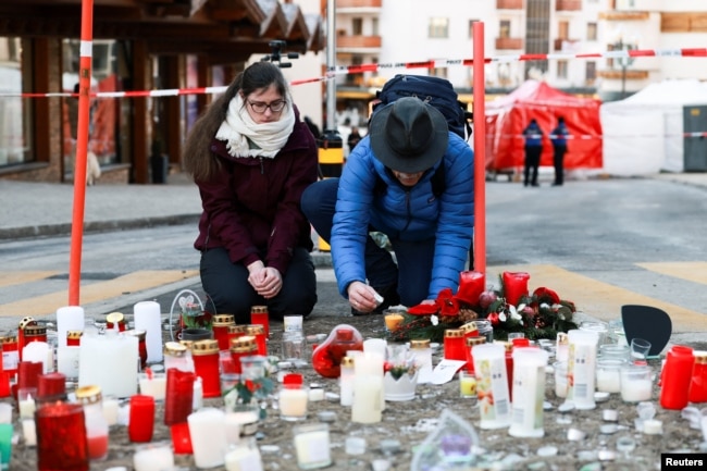 Мъж запалва свещ в памет на жертвите от пожара. Кран Монтана, 2 януари 2026 г.