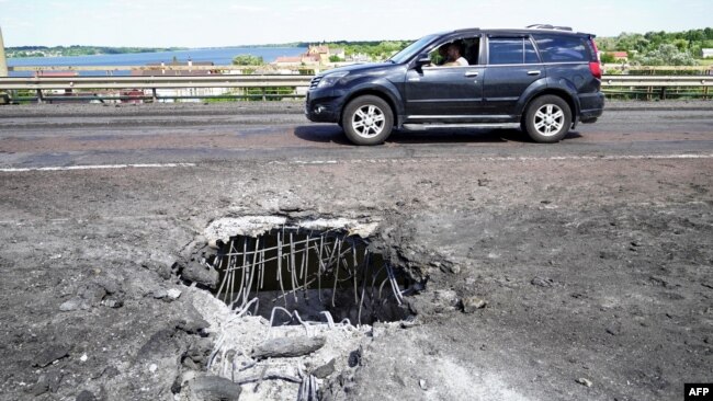 Воронка на Антоновском мосту в Херсоне через реку Днепр после одного из первых ударов ВСУ. Херсон, 21 июля 2022 года