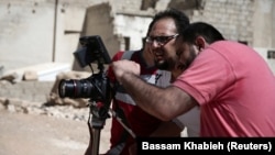 Syrian director Humam Husari (right) films a scene in a rebel-held district in the Damascus suburbs in September 2016.