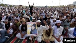 A man holds a picture of Mumtaz Qadri as he chants slogans with others during a sit in protest against Qadri's execution in front of the Parliament building in Islamabad on March 29.