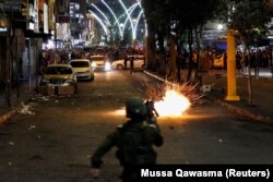 Шумавая граната, якую выпусцілі ізраільскія сілы, выбухае падчас антыізраільскага пратэсту ў Хэўроне на Заходнім беразе Ярдану, 11 траўня 2021