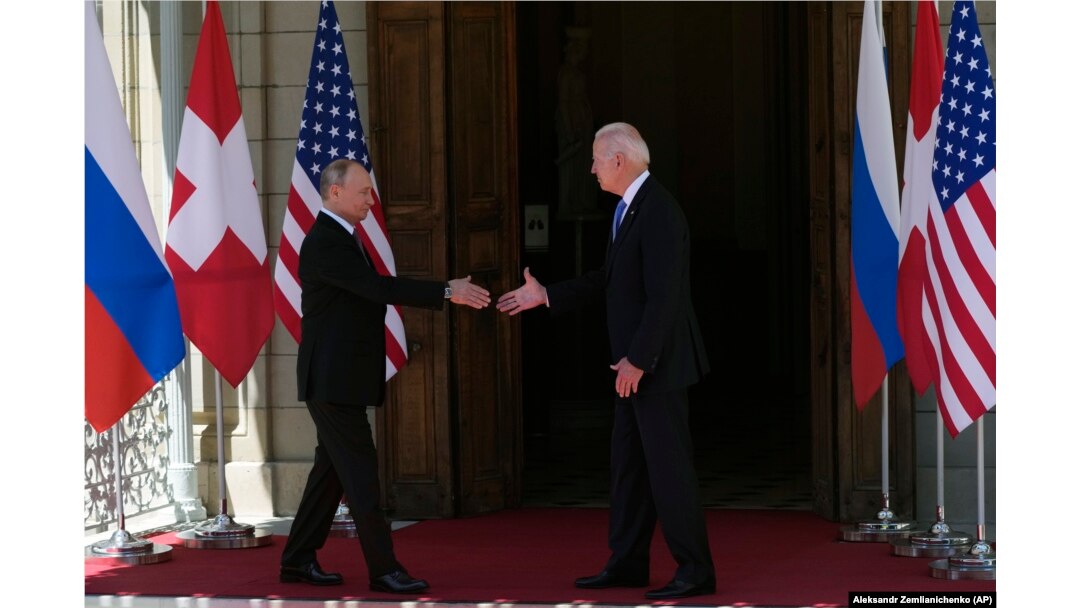 Vladimir Putin și Joe Biden dau mâna înainte să intre în clădirea în care are loc summit-ul.