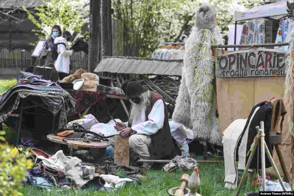 Un artizan realizează opinci și alte obiecte din piele în incinta Muzeului Satului din București, cu ocazia Târgului de Florii.