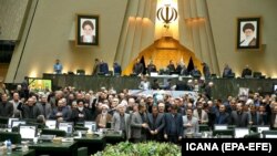 Iranian lawmakers holding pictures of slain Iran's Quds Force leader Qasem Soleimani as they chant 'death to America', during a parliament session in Tehran, January 7, 2020