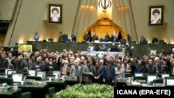 Iranian lawmakers holding pictures of slain Iran's Qods Force leader Qassem Soleimani as they chant 'death to America', during a parliament session in Tehran, January 7, 2020