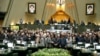 Iranian lawmakers holding pictures of slain Iran's Qods Force leader Qassem Soleimani as they chant 'death to America', during a parliament session in Tehran, January 7, 2020