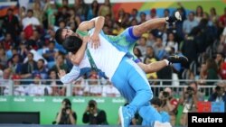 Wrestler Ikhtiyor Navruzov of Uzbekistan celebrates with his coach after winning a bronze medal.