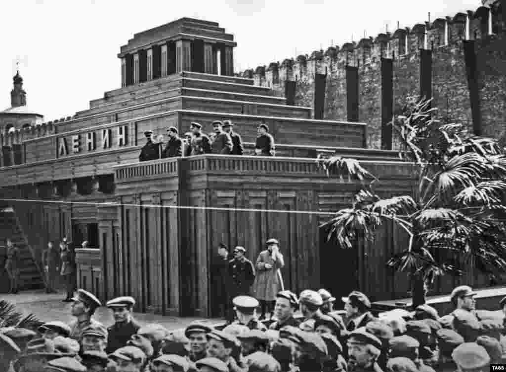 Bolshevik leaders, including Josef Stalin (third from right, looking toward the camera), on the viewing platform of the second mausoleum in 1926.&nbsp; In March 1924, this more substantial wooden mausoleum was built by Shchusev. Several issues had been encountered with the first, smaller design, including warmth generated from the constant flow of mourners that risked rotting Lenin&rsquo;s remains.