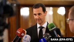 Syrian President Bashar al-Assad speaks to reporters after a meeting with Russian Deputy Prime Minister Dmitry Rogozin in Damascus on December 18. (file photo)