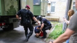 Police beat a protester in Kyiv on June 15.