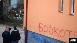 Grupa građana severne Mitrovice pored grafita koji pozivaju na bojkot kosovskih izbora, novembar 2013.