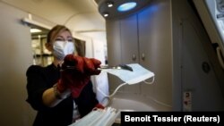 Një punëtore duke shpërndarë maska kundër koronvirusit për udhëtarët nga aeroporti i Parisit. 