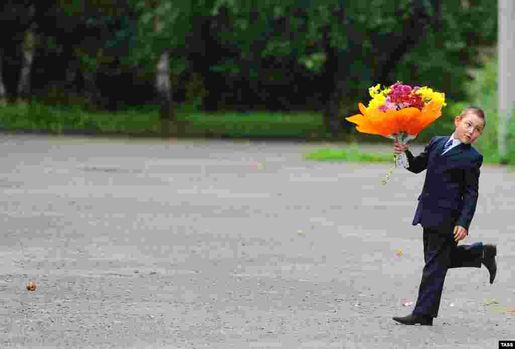 A Russian boy walks with a bouquet of flowers for his teacher on the first day of school in Ivanovo. (ITAR-TASS/Vladimir Smirnov)