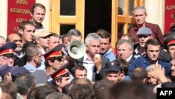 Один из лидеров абхазской оппозиции Рауль Хаджимба (c мегафоном) на митинге перед зданием администрации президента в Сухуме, 27 мая 2014 г.