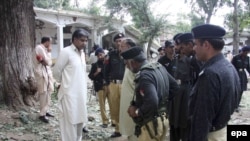 Pakistani Army soldiers and police secure the site where a suicide bomber killed more than 13 police recruits in a police training camp in Mingora on August 30.
