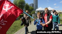 Чалавек з партрэтам Сталіна на майцы і савецкім сьцягам. Ілюстрацыйнае фота