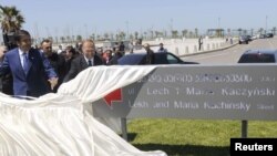 Georgian President Mikheil Saakashvili (left) helps to unveil a sign bearing street names of the late Polish President Lech Kaczynski and his wife, Maria, in Batumi.