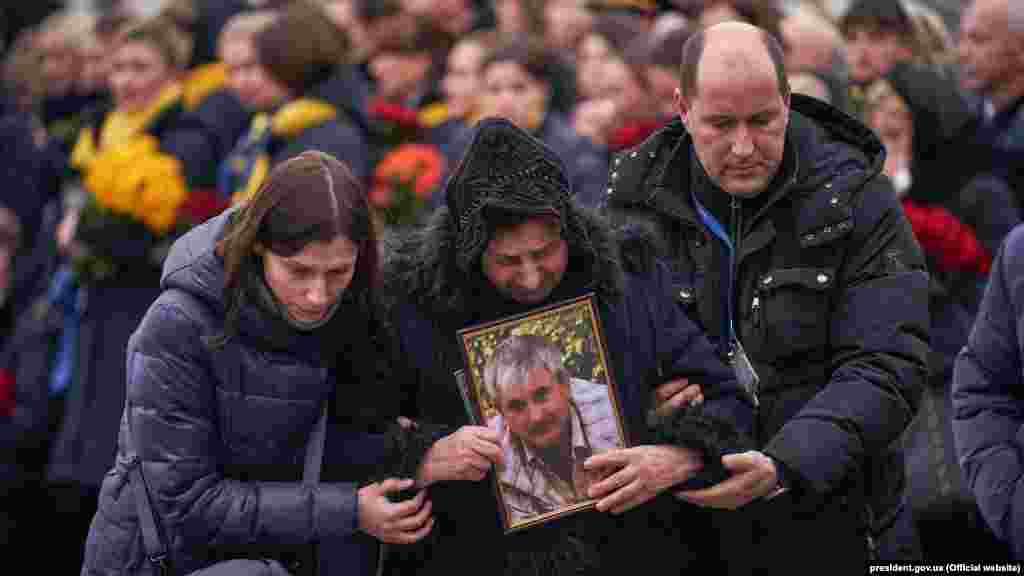 Relatives hold a picture of Flight PS572 pilot Volodymyr Haponenko. He is survived by his wife and two daughters.
