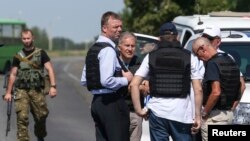 Alexander Hug (front enter), deputy head for the OSCE monitoring mission in Ukraine, stands with members of his team on a failed attempt to reach the site in eastern Ukraine where the downed Malaysian airliner MH17 crashed, outside Donetsk.