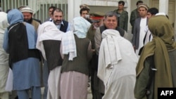 Kandahar Governor Tooryalai Wesa (right, facing camera) greets Taliban fighters as they peacefully surrender arms during a meeting with Afghan government officials as part of the government's peace and reintegration process in Kandahar in 2011.
