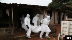 پرستاران لیبریایی در حال انتقال جسد یک فرد مبتلا به بیماری ابولا برای خاکسپاری.