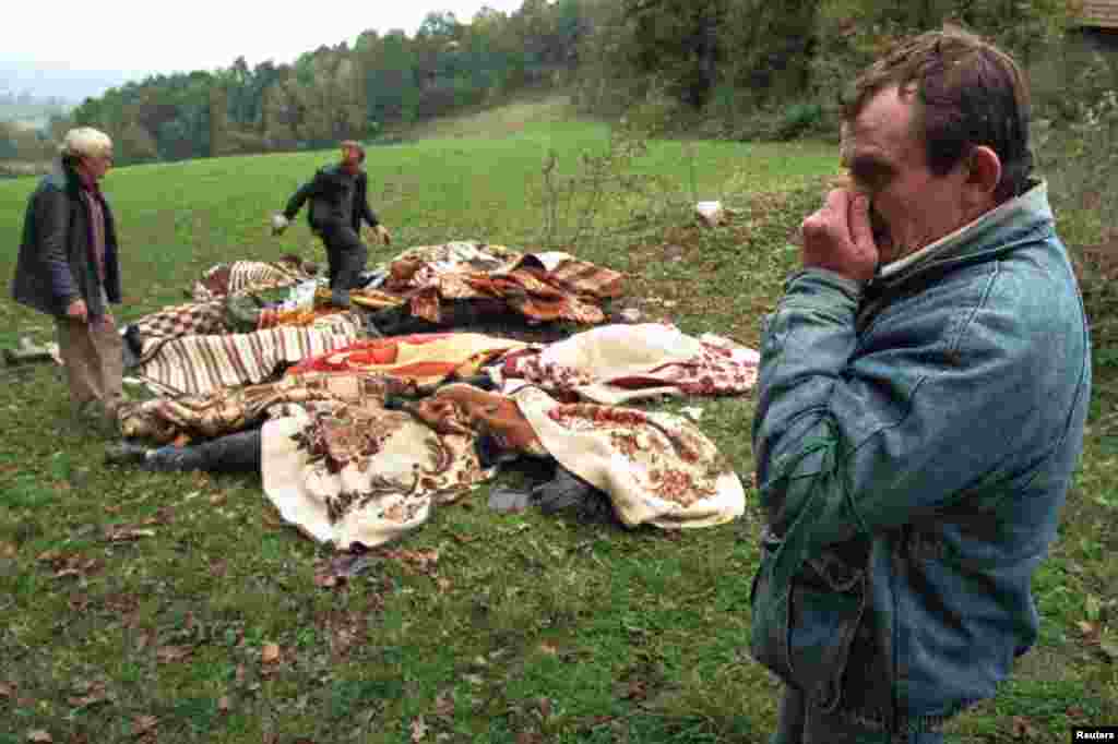 Duhoarea morții. Un croat se ține de nas în timp ce ajută la colectarea cadavrelor descompuse a 15 oameni lăsate să putrezească într-o poiană în nordvestul Bosniei, în 16 octombrie 1995. Numeroase gropi comune au fost descoperite după ce retragerea sîrbilor din nordvestul Bosniei. 