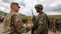Një ushtar amerikan duke biseduar me një pjesëtar të FSK-së.