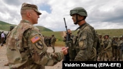 Američki vojnik (levo) razgovara s vojnikom Kosovskih bezbednosnih snaga (KSF) posle vežbe "Defender Europe 21", Kosovo, 28. maja 2021.