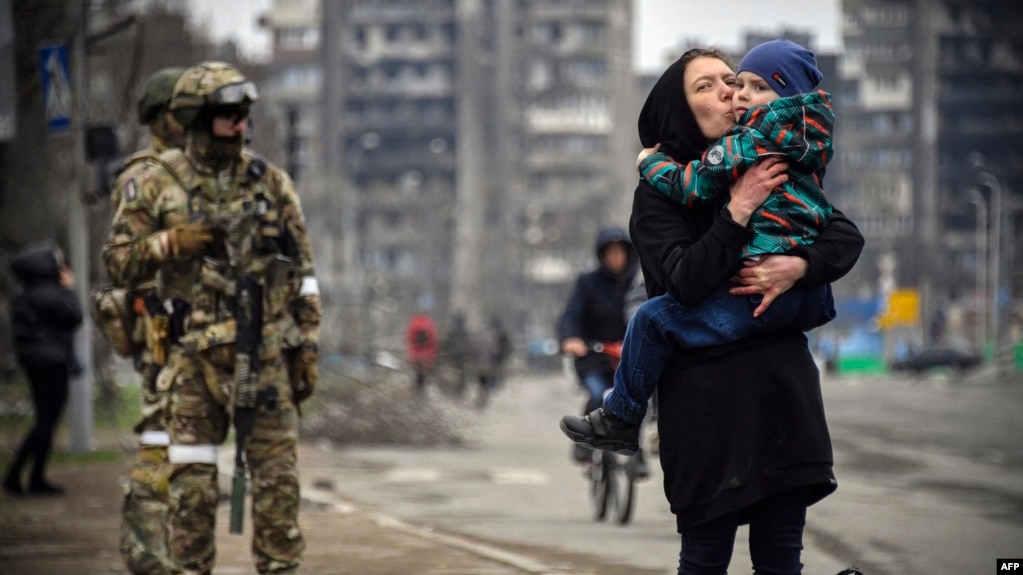 Цивільні поруч із російськими солдатами під час захоплення арією РФ Маріуполя. 12 квітня 2022 року