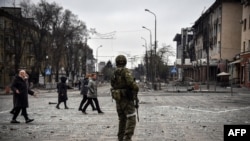 Российский военный на улице разрушенного Мариуполя, Украина