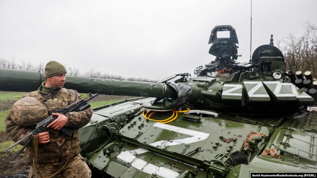 Український військовослужбовець біля пошкодженого російського танка Т-72БЗ під час масштабного вторгнення Росії до України. Ілюстративне фото