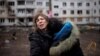 Две женщины плачут во дворе обстрелянного российской армией жилого дома в Харькове, 13 апреля 2022 года