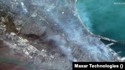 Сателитна снимка на Maxar Technologies от 9 април 2022 г. показва дим от ракетни взривове над украинския град Мариупол